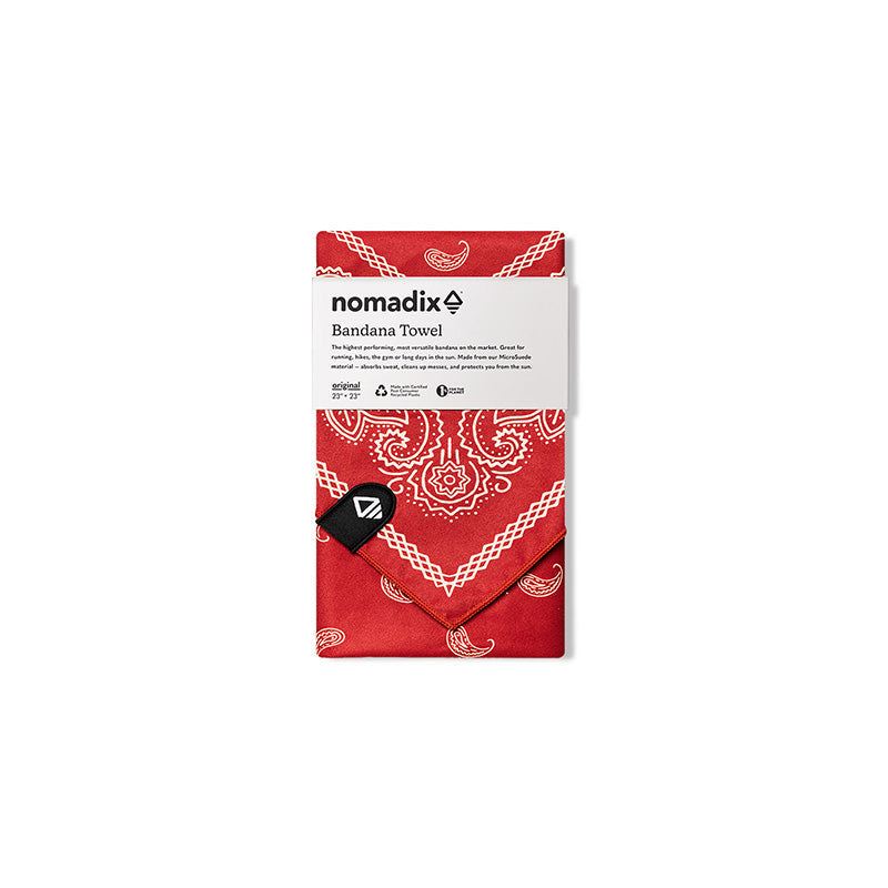 Nomadix Bandana Towel in red with white paisley design, folded and packaged with branding label.