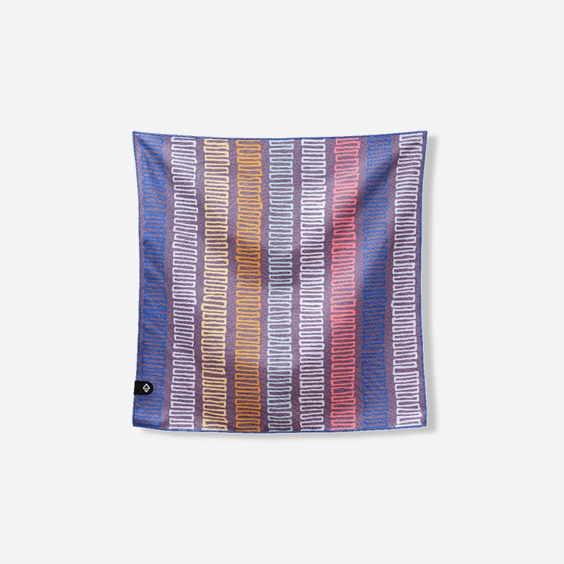 Nomadix Bandana Towel with colorful striped pattern featuring looped designs in blue, yellow, orange, and red, front view.