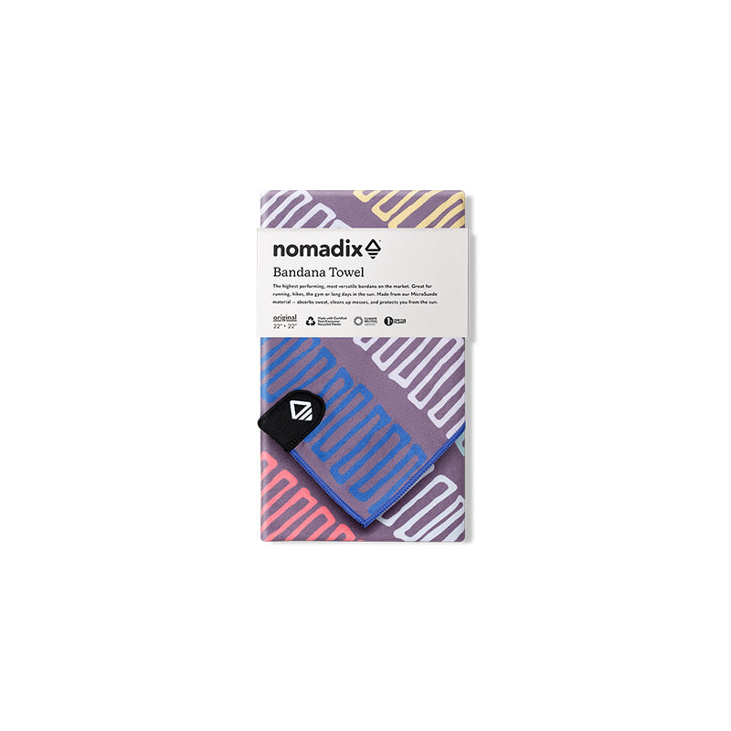 Nomadix Bandana Towel in purple with multicolored geometric patterns and black corner logo, front packaging view.
