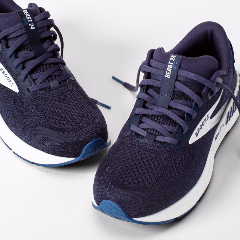 Navy running shoes with white soles on a light gray background