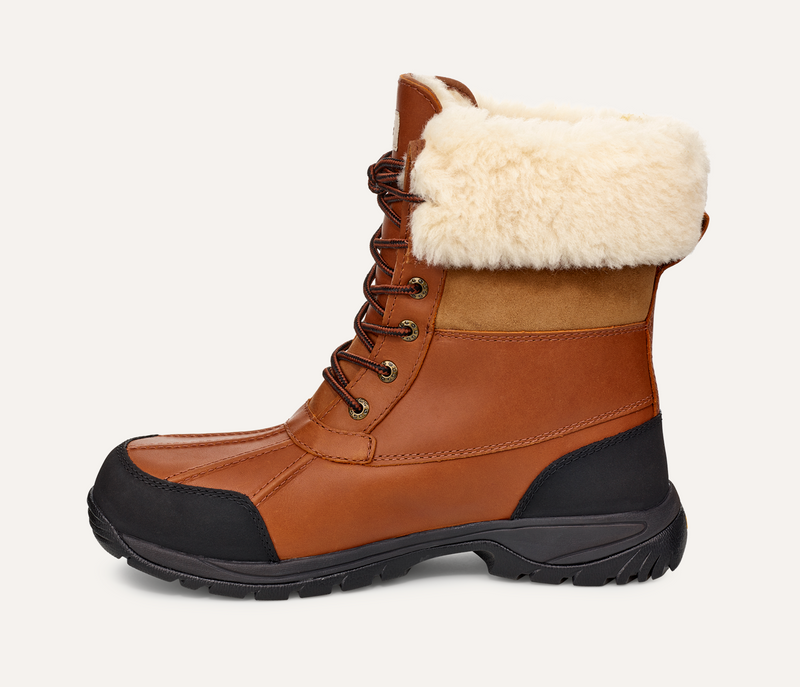 UGG Butte winter boots in brown leather with black waterproof accents and soft white fleece collar, side view.