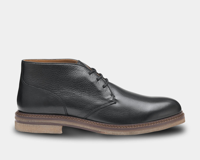 A black full-grain leather chukka boot with a crepe rubber sole and contrast edge detail.