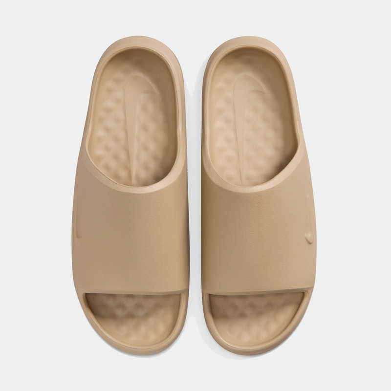 Nike Calm Slide 2.0 sandals in beige with textured footbed and open-toe design, top view.
