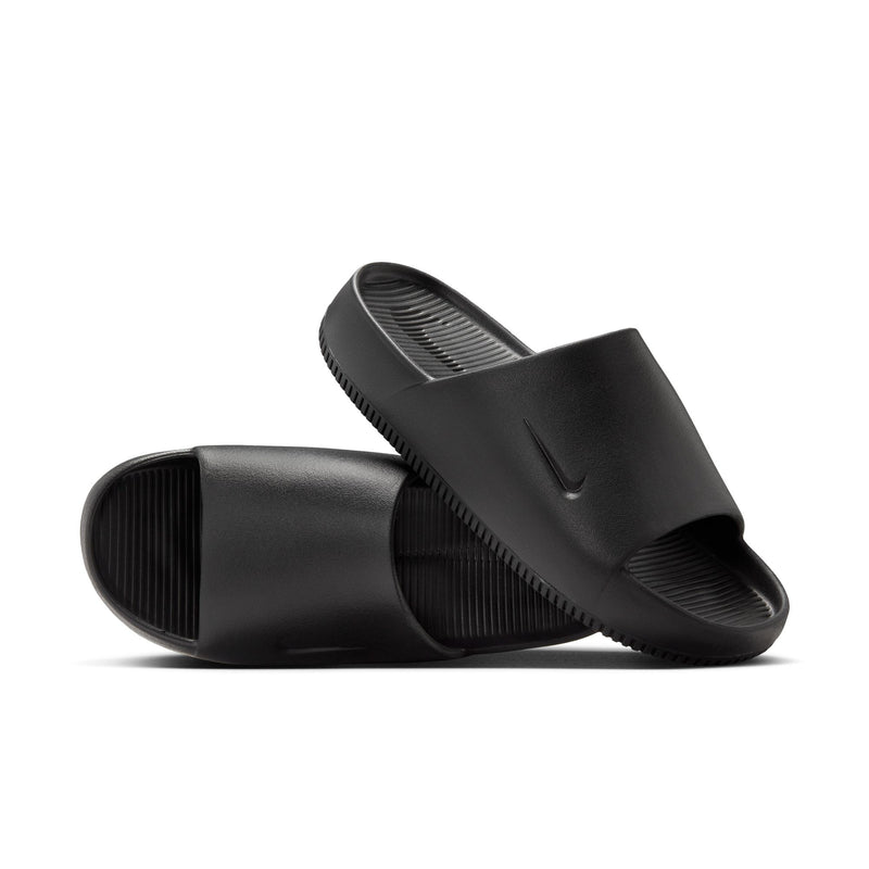 Nike Calm Slide sandals in black with textured footbed, minimalist design, and embossed logo, angled side view.