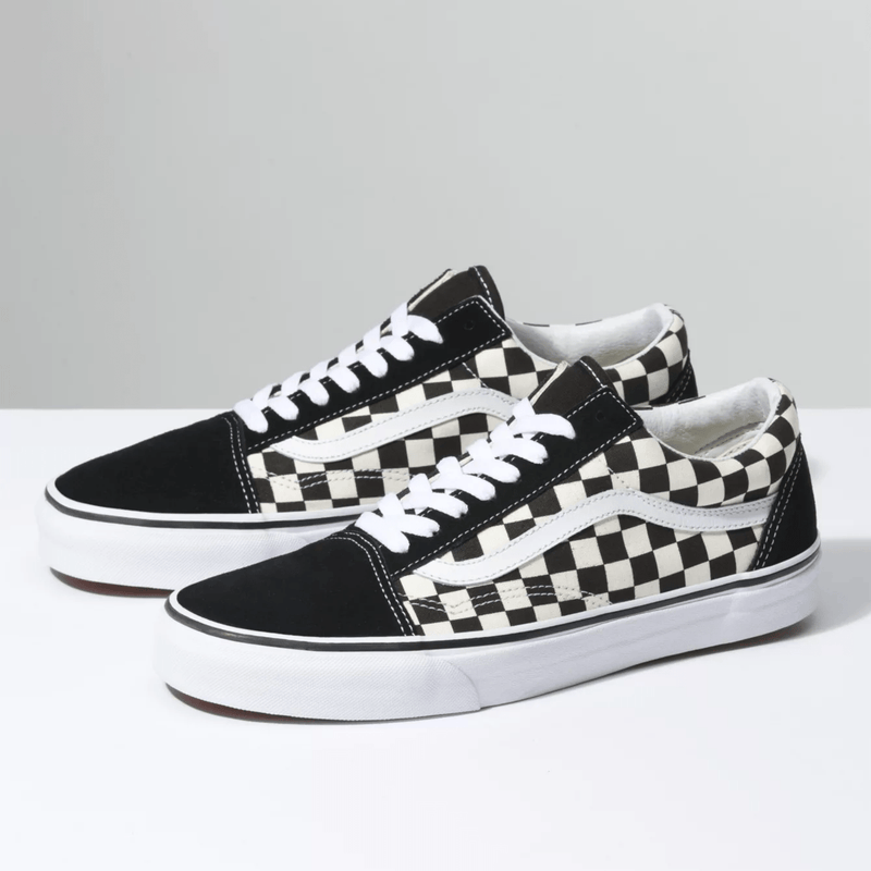 Vans Checkerboard Old Skool sneakers featuring black suede and black-and-white checkerboard canvas upper with white side stripe and laces, angled front-side view.