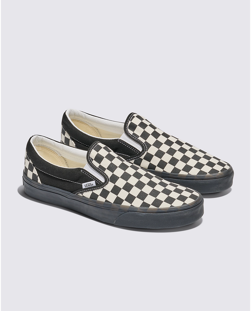 Vans Checkerboard Slip On shoes with black and white checkered canvas upper, elastic side accents, and black rubber outsole, angled side view.