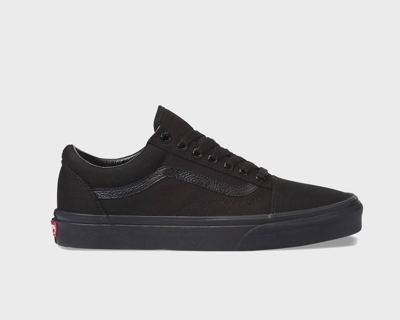 Vans Classic Old Skool sneakers in all-black suede and canvas with a signature side stripe and rubber waffle sole, side view.