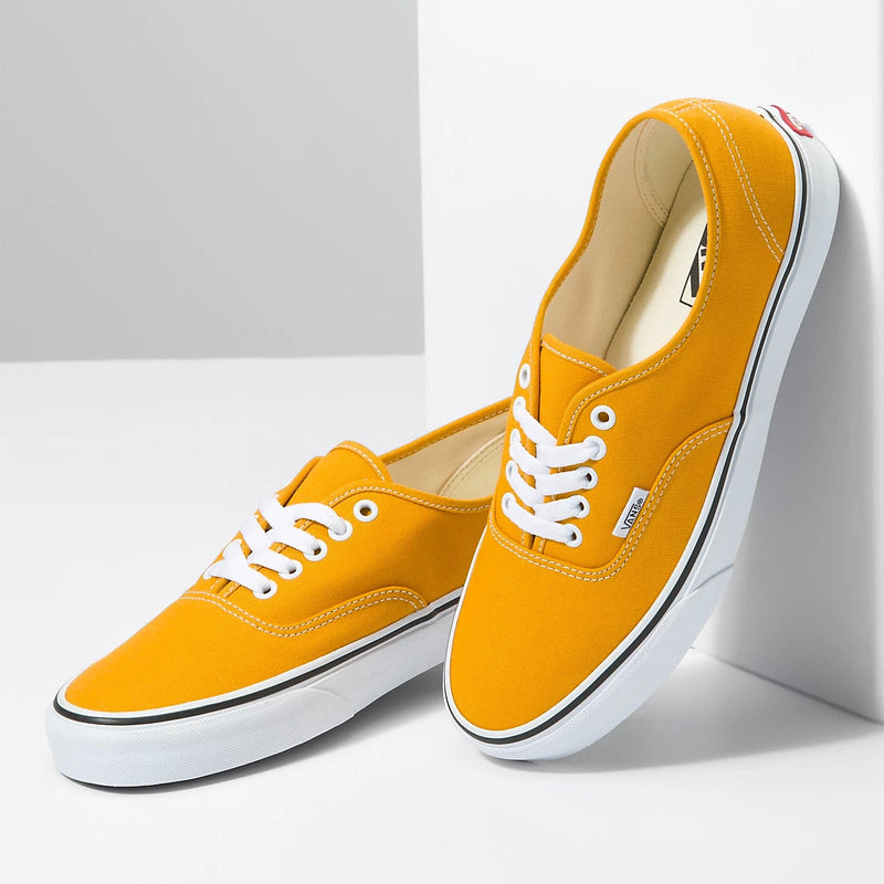 Vans Color Theory Authentic sneakers in vibrant yellow canvas with white laces and waffle outsole, angled side view.
