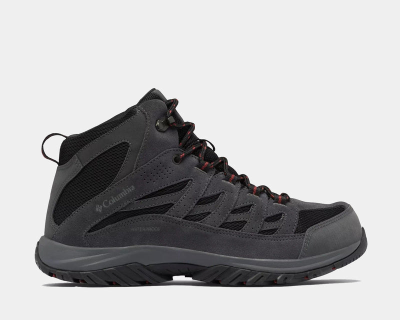 Columbia Crestwood Mid Waterproof hiking boots in dark gray with black mesh panels and red lace accents, side view.