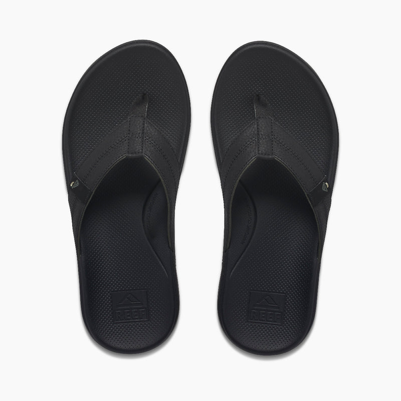Reef Cushion Phantom 2.0 sandals in black with textured footbed and durable thong straps, top view.