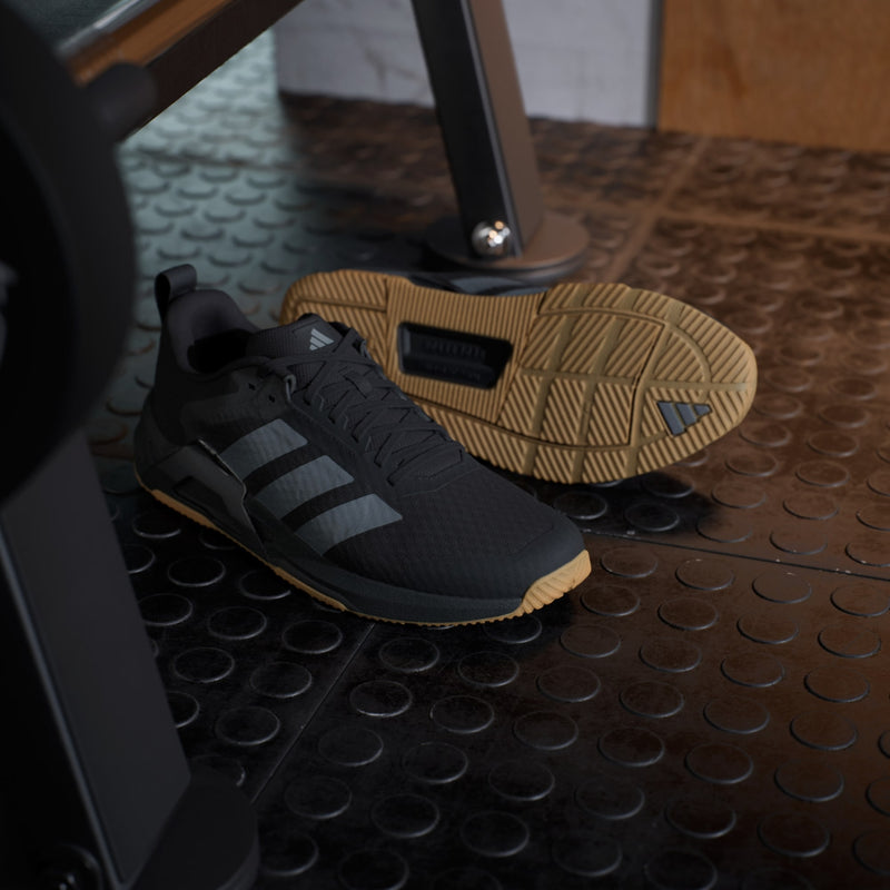 Adidas Dropset Control Trainer training shoes in black with gum sole, side view showcasing mesh upper and signature stripes.