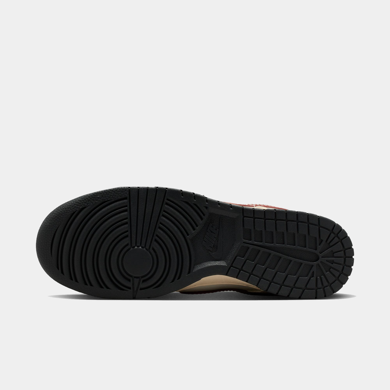 Nike Dunk Low sneaker outsole in black rubber showing circular tread patterns and Nike logo detailing, sole/bottom view.