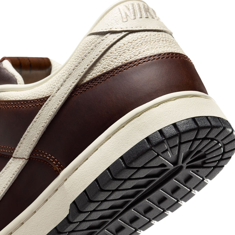Nike Dunk Low sneakers with brown leather upper and textured cream overlays, black rubber outsole, and heel detail.