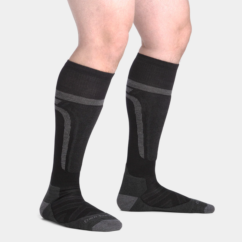 Darn Tough Edge Over-the-Calf Midweight Ski & Snowboard Socks in black and gray with reinforced cushioning, side view worn.
