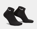Nike Everyday Cushion Low Socks in black with white Nike logo and ribbed cuffs, side-angle view.