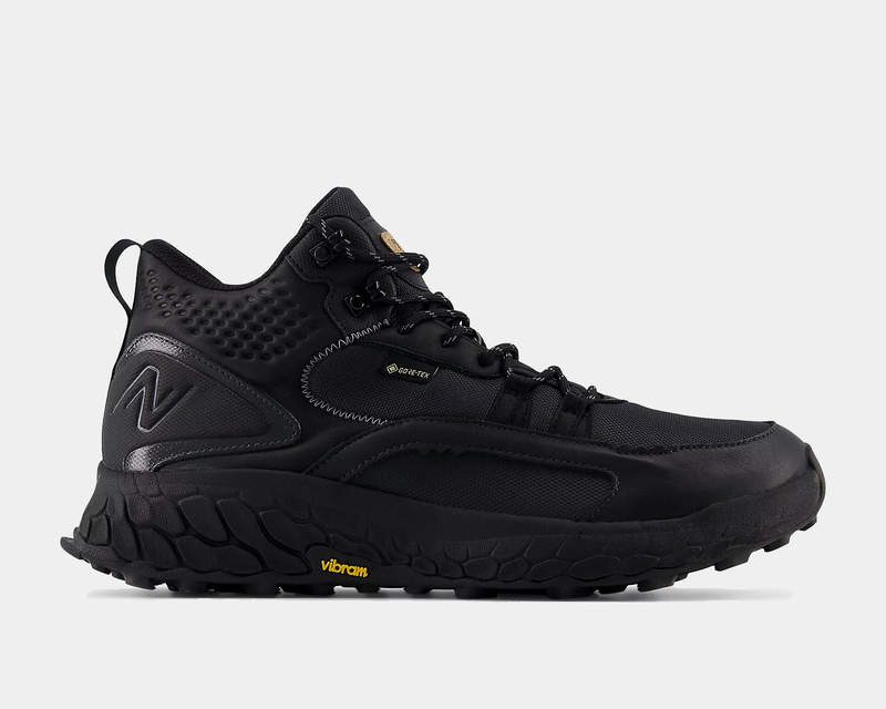 New Balance Foam X Hierro Mid GTX hiking shoes in black with GORE-TEX waterproof upper and Vibram outsole, side view.