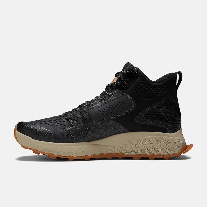 New Balance Foam X Hierro Mid GTX hiking boots in black with rugged mesh upper, tan cushioned midsole, and gum outsole, side view.