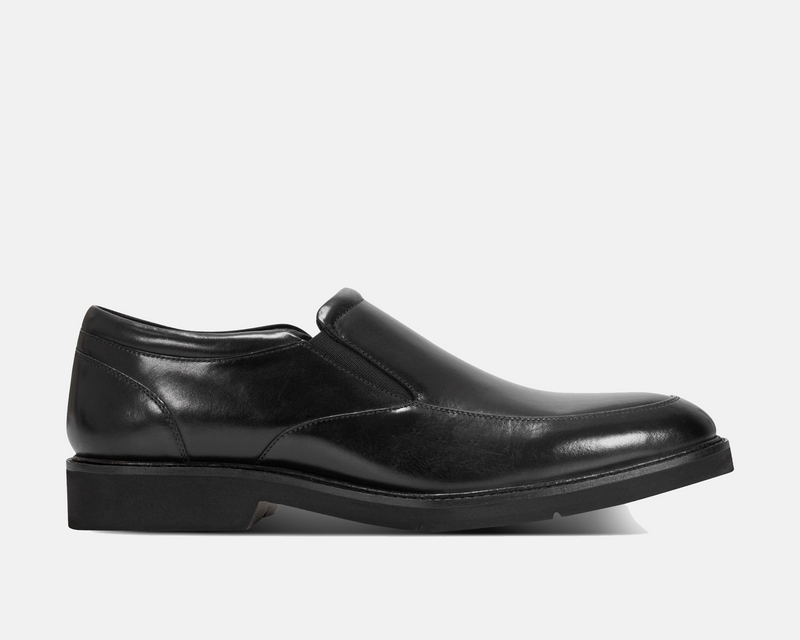 Rockport Folton Almond Toe Slip On shoes in black leather with sleek design and elastic gussets, side view.
