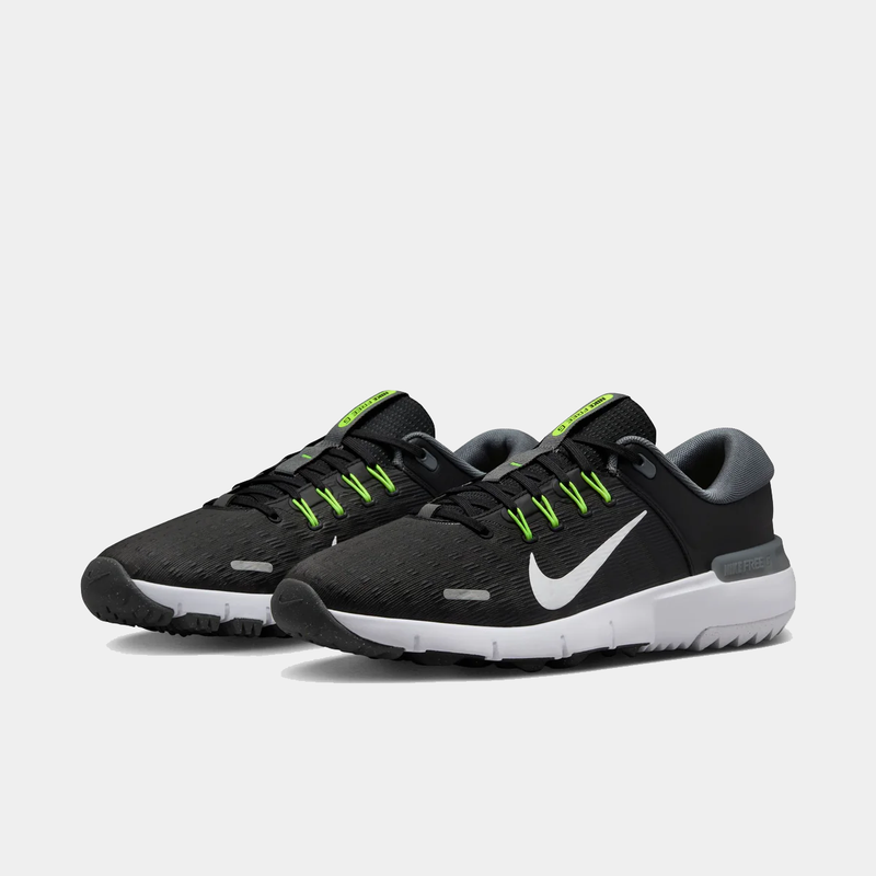 Nike Free Golf Next Nature shoes in black with white midsole, bright green lace eyelets, and gray accents, front angle view.