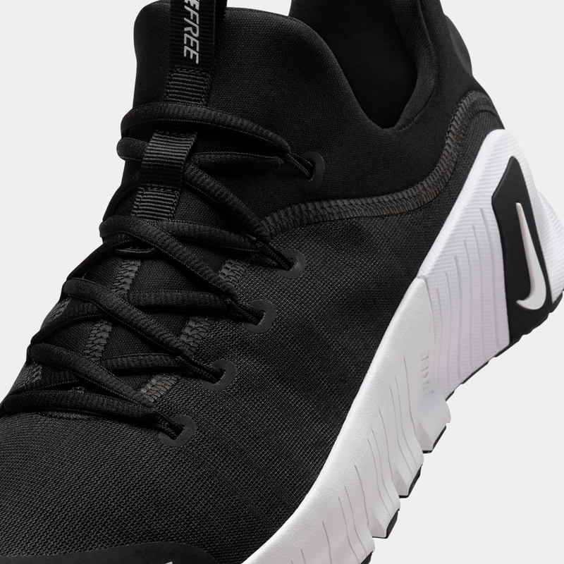 Nike Free Metcon 6 TB training shoes in black with breathable mesh upper and white midsole, angled close-up of laces and side detailing.