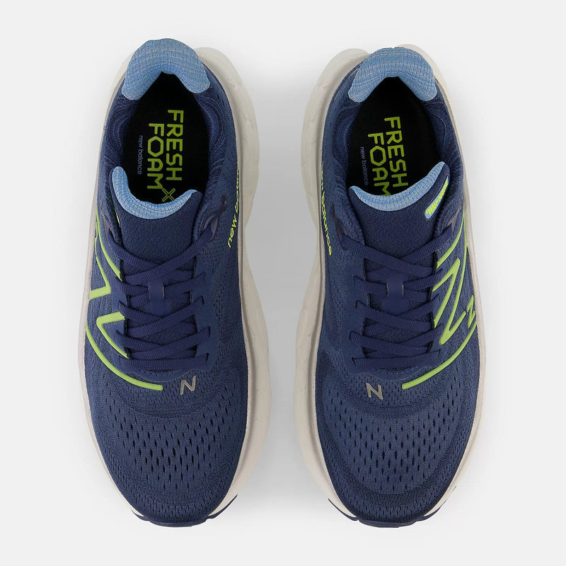 New Balance Fresh Foam More v4 running shoes in navy blue with breathable mesh upper and neon green accents, top view.