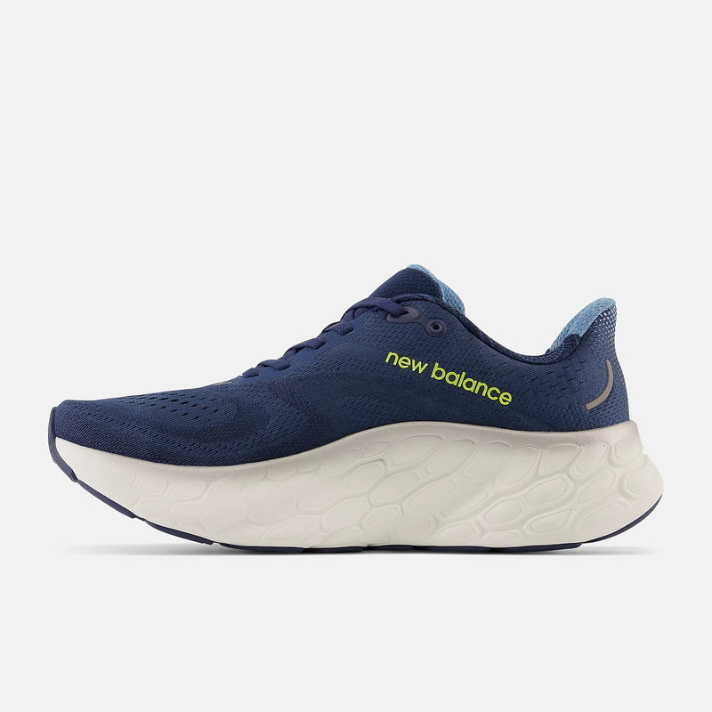 New Balance Fresh Foam More v4 running shoes, side view in navy blue with breathable mesh upper, foam midsole, and neon yellow branding.