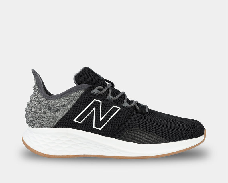 New Balance Golf Fresh Foam ROAV Golf shoes in black and gray with a cushioned white midsole and gum outsole, side view.