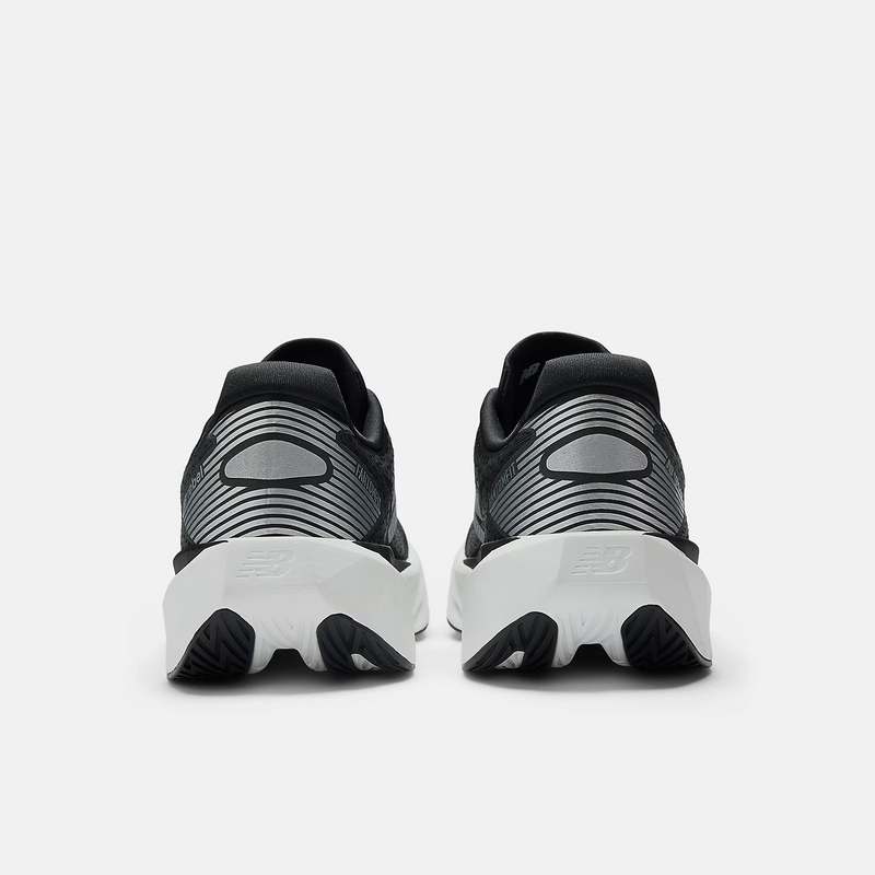 New Balance FuelCell Rebel v5 running shoes in black and white with striped detailing on heel counter and sculpted midsole, back view.