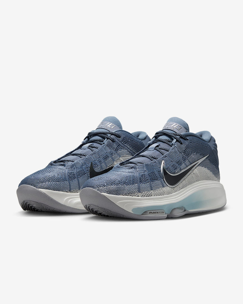 Nike G.T. Hustle 3 basketball shoes in blue with breathable mesh upper, Air Zoom cushioning, and black swoosh logo, front angle view.