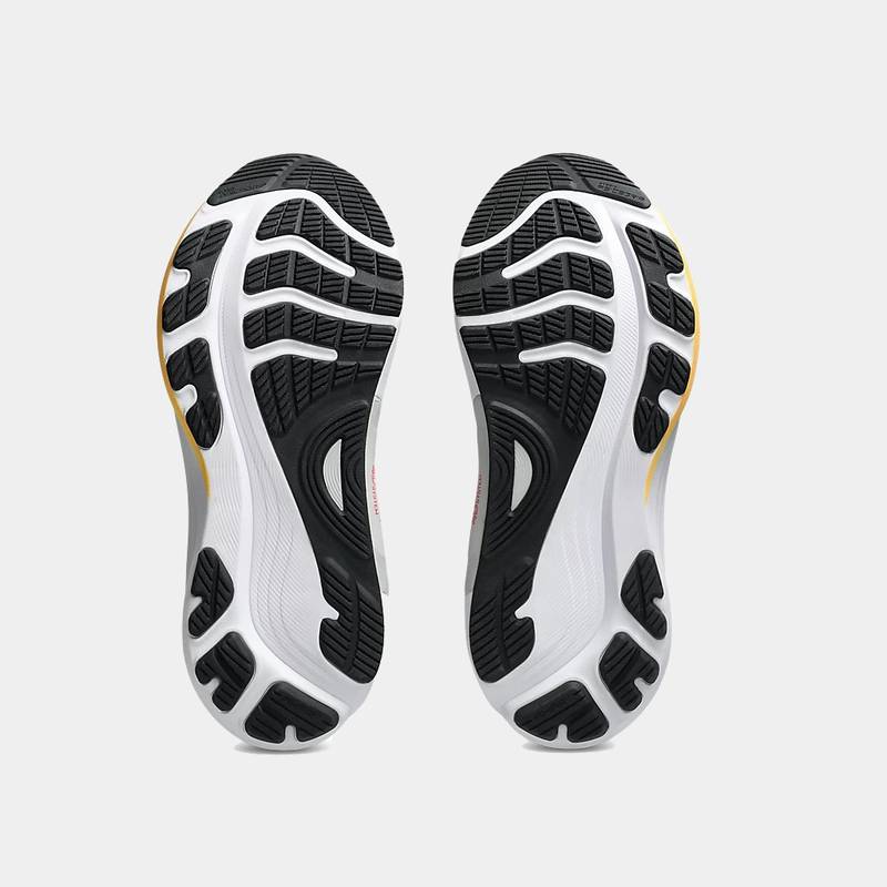 Asics Gel-Kayano 32 running shoe soles showing black rubber tread pattern and white midsole with yellow accents, bottom view.