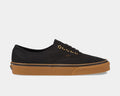 Vans Gum Authentic sneakers in black canvas with gold eyelets and gum rubber outsole, side view.