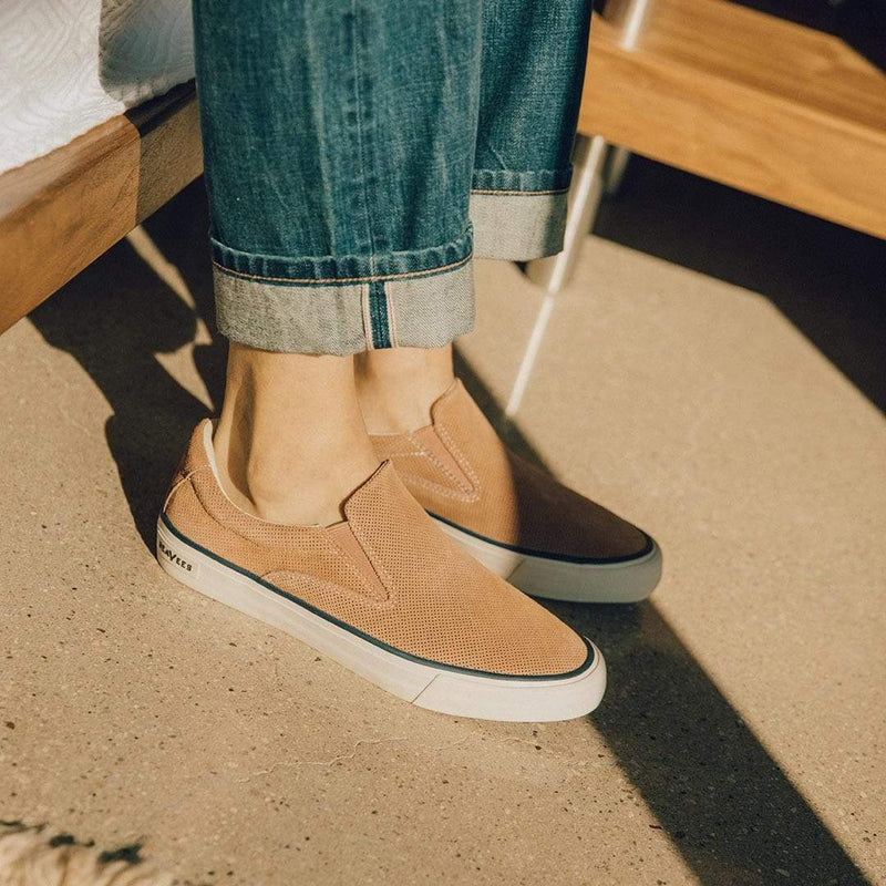 SeaVees Hawthorne Slip On shoes in tan suede with perforated upper and white rubber sole, worn casually indoors.