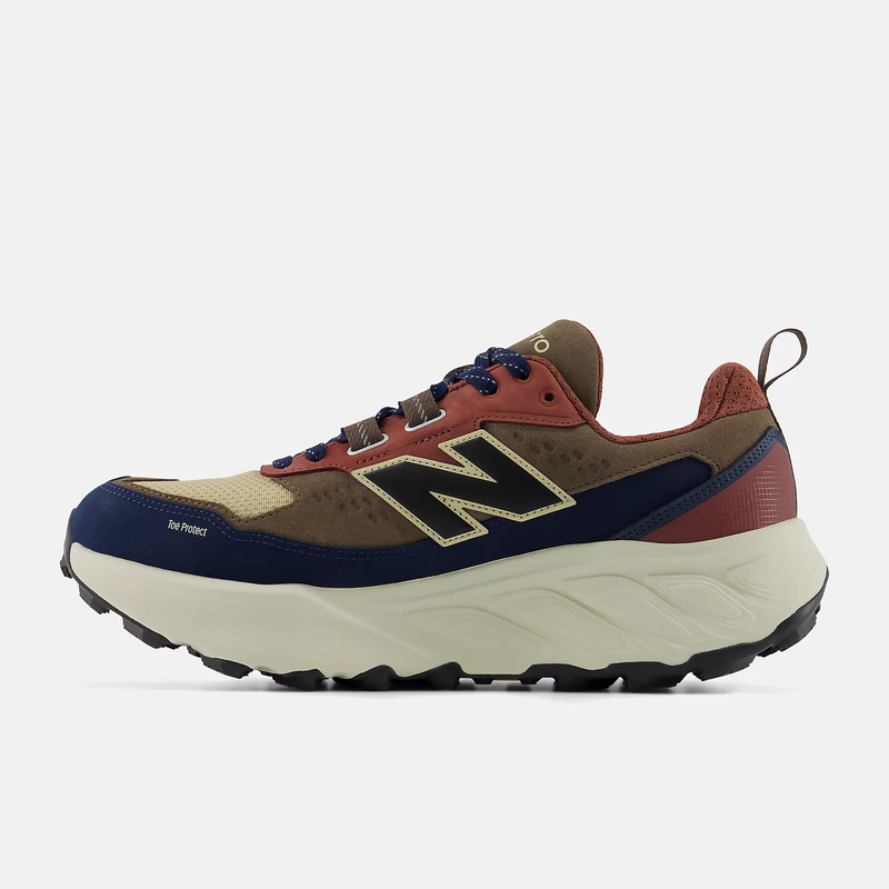 New Balance Hierro Trek hiking shoes, side view showcasing multi-tone design in navy blue, beige, and rust red with rugged outsole and padded upper.