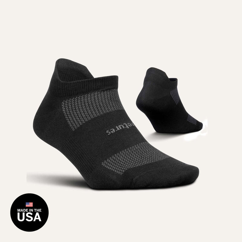 Feetures High Performance Max Cushion No Show Tab socks in black with cushioned sole and moisture-wicking fabric, side view.