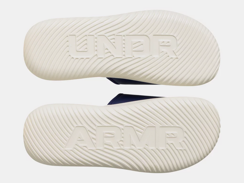 Under Armour Ignite Pro 8 Slides outsole in white, featuring embossed logo and textured grip pattern, bottom view.
