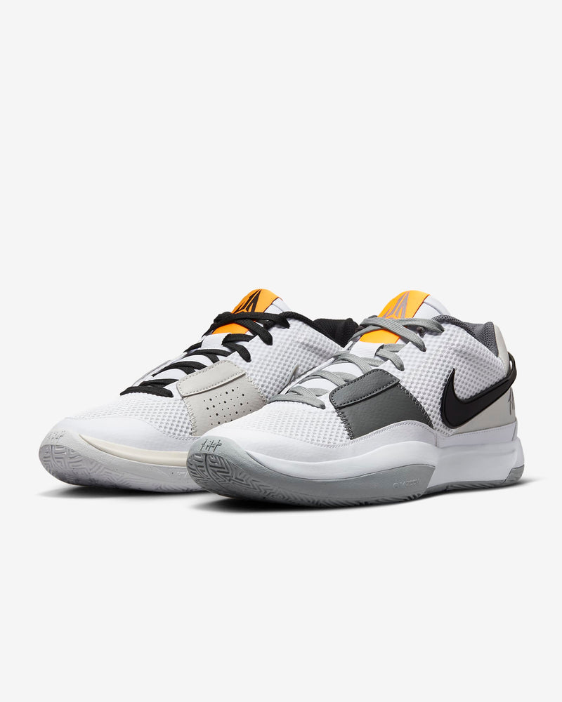 Nike Ja 1 "Wet Cement" basketball shoes with a white mesh upper, gray overlays, black Swoosh, and orange tongue accents, front angled view.