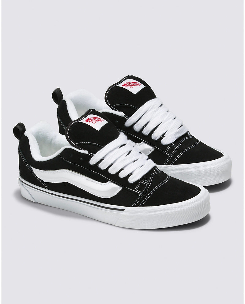 Vans Knu Skool Core sneakers in black suede with white stripe detailing, oversized laces, and padded collars, angled view.