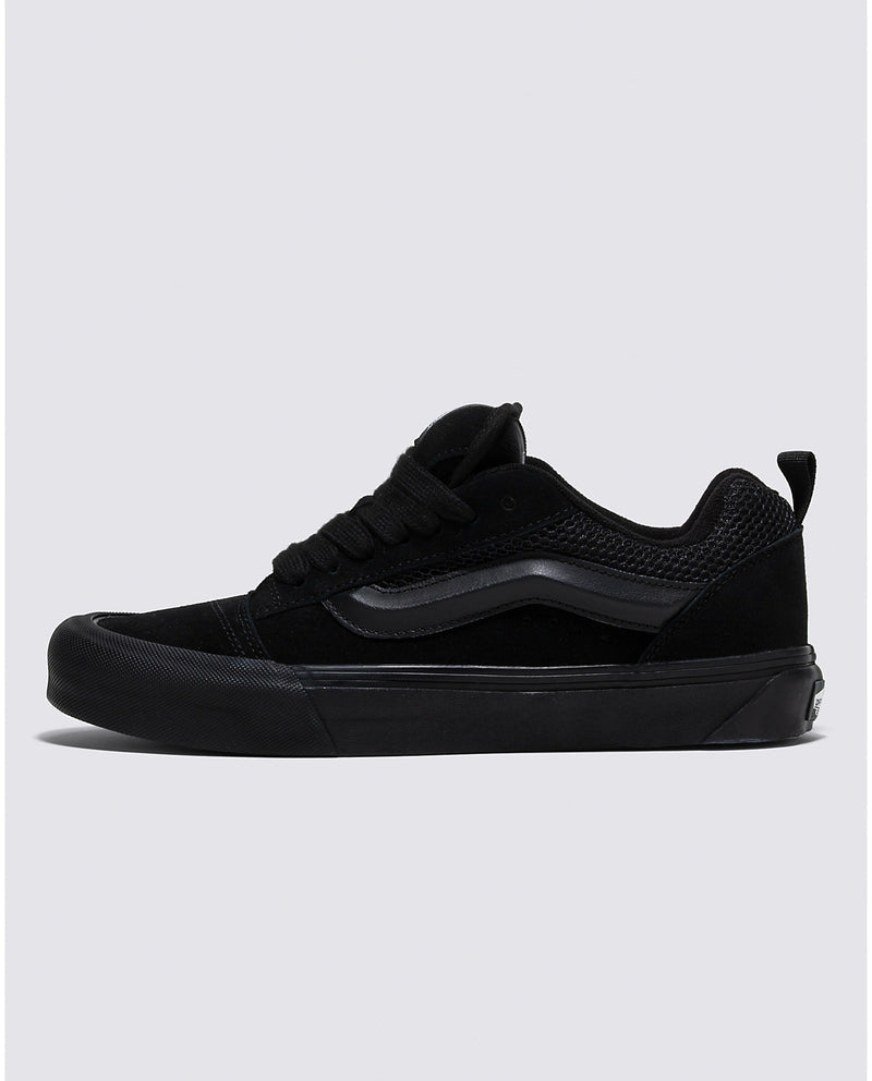 Vans Knu Skool Core sneakers in all-black with suede and mesh upper detailing, thick sole, and signature side stripe, side view.