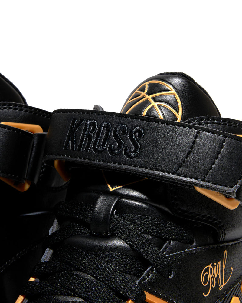 Ewing Athletics KROSS X "BIG L" sneakers in black with gold accents, bold KROSS strap detail, and signature embroidery, close-up view.