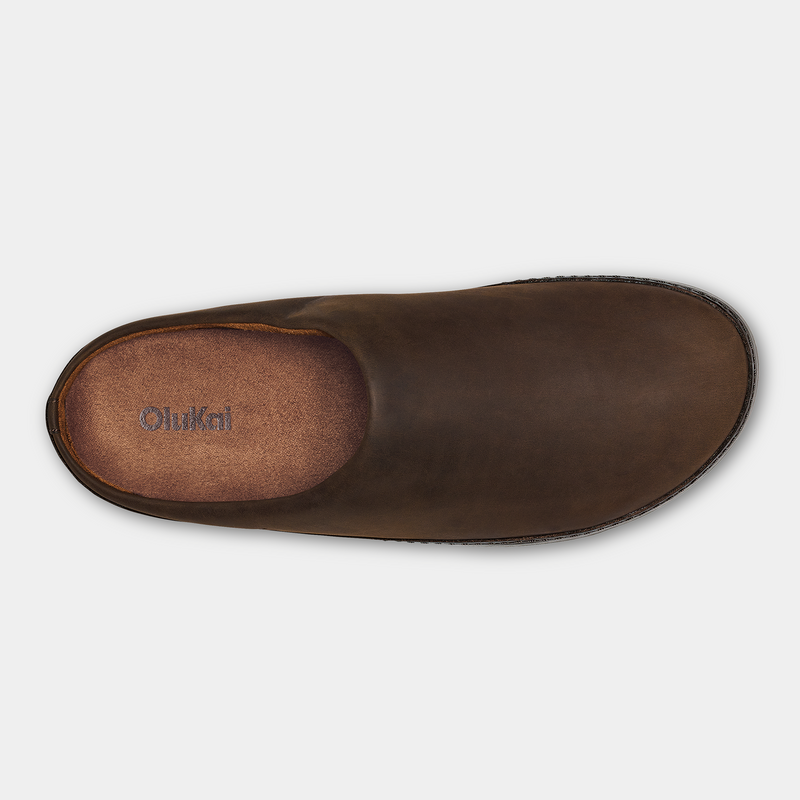 OluKai Ku'u slip-on shoes in rich brown leather with a cushioned insole and minimalist design, top view.