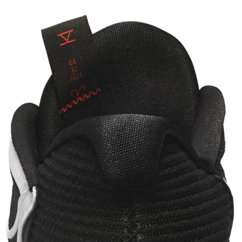 Nike Kyrie Low 5 basketball shoes in black showing padded heel collar design and tongue details with red stitching, close-up view.