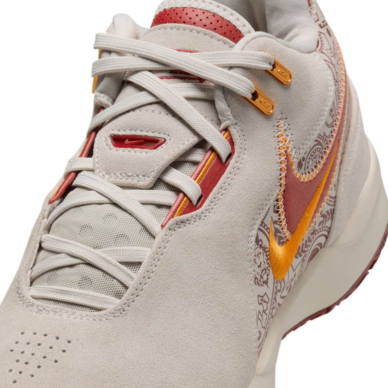 Nike LeBron NXXT Gen AMPD sneakers in beige with red and orange accents, suede upper, and intricate paisley detailing, close-up front view.