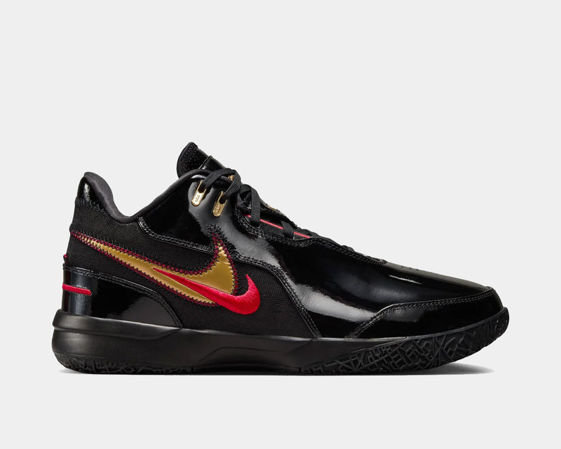 Nike LeBron NXXT Gen AMPD basketball shoes in black with glossy panels, gold and red Swoosh accents, side view.