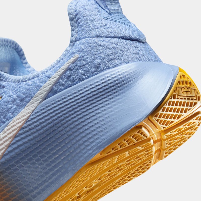 Close-up of a blue sneaker with a yellow sole on a light gray background