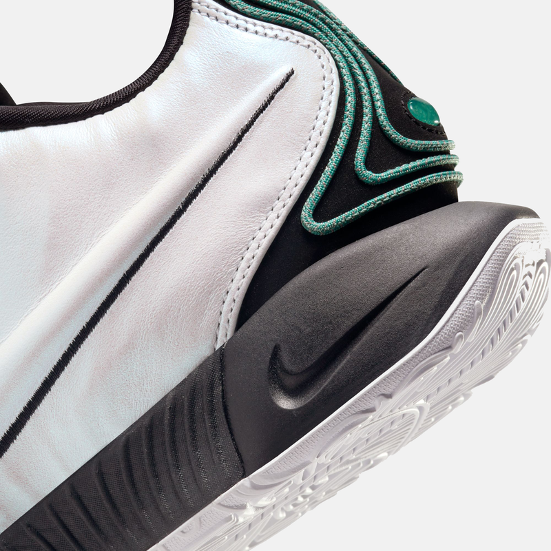 Nike Lebron XXI "Conchiolin" basketball shoes, close-up side view showing white leather upper, black midsole, teal accents, and textured outsole.