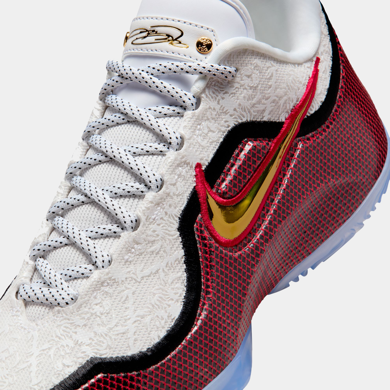 Nike LeBron XXIII "Grand Opening" basketball shoes, detailed side view showing white textured upper, red mesh overlays, gold metallic Swoosh, and black accents.