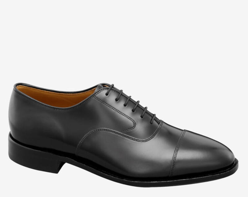 Johnston & Murphy Melton Cap Toe dress shoes in black leather with sleek cap toe design and lace-up closure, side view.