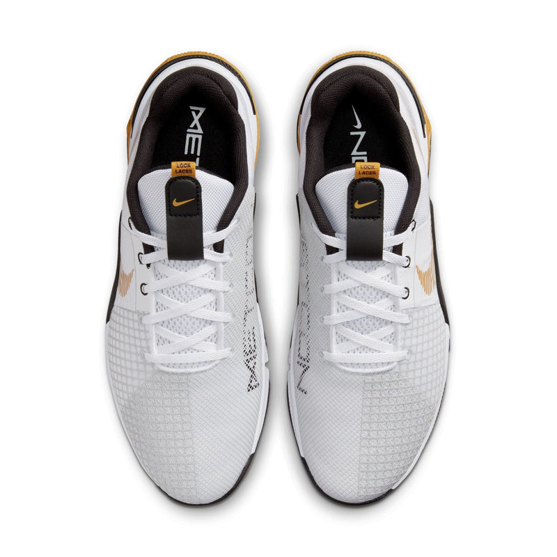 Nike Metcon 8 training shoes top view in white with mesh upper, black and gold accents, and "Lock Laces" system.