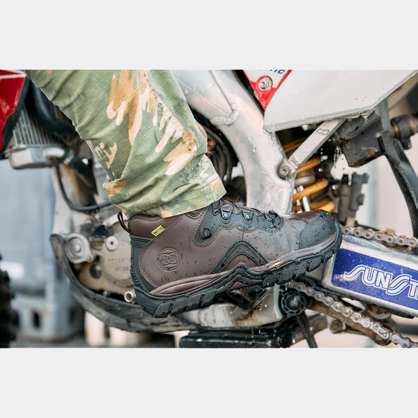 DC WorkCrew Navigator Work Hi Top Comp Toe with Met Guard work boots in dark brown leather with reinforced toe and water-resistant design, worn by rider on motorcycle.