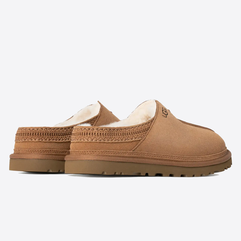 UGG Neuman slippers in chestnut brown suede with sheepskin lining and textured rubber outsole, side view.
